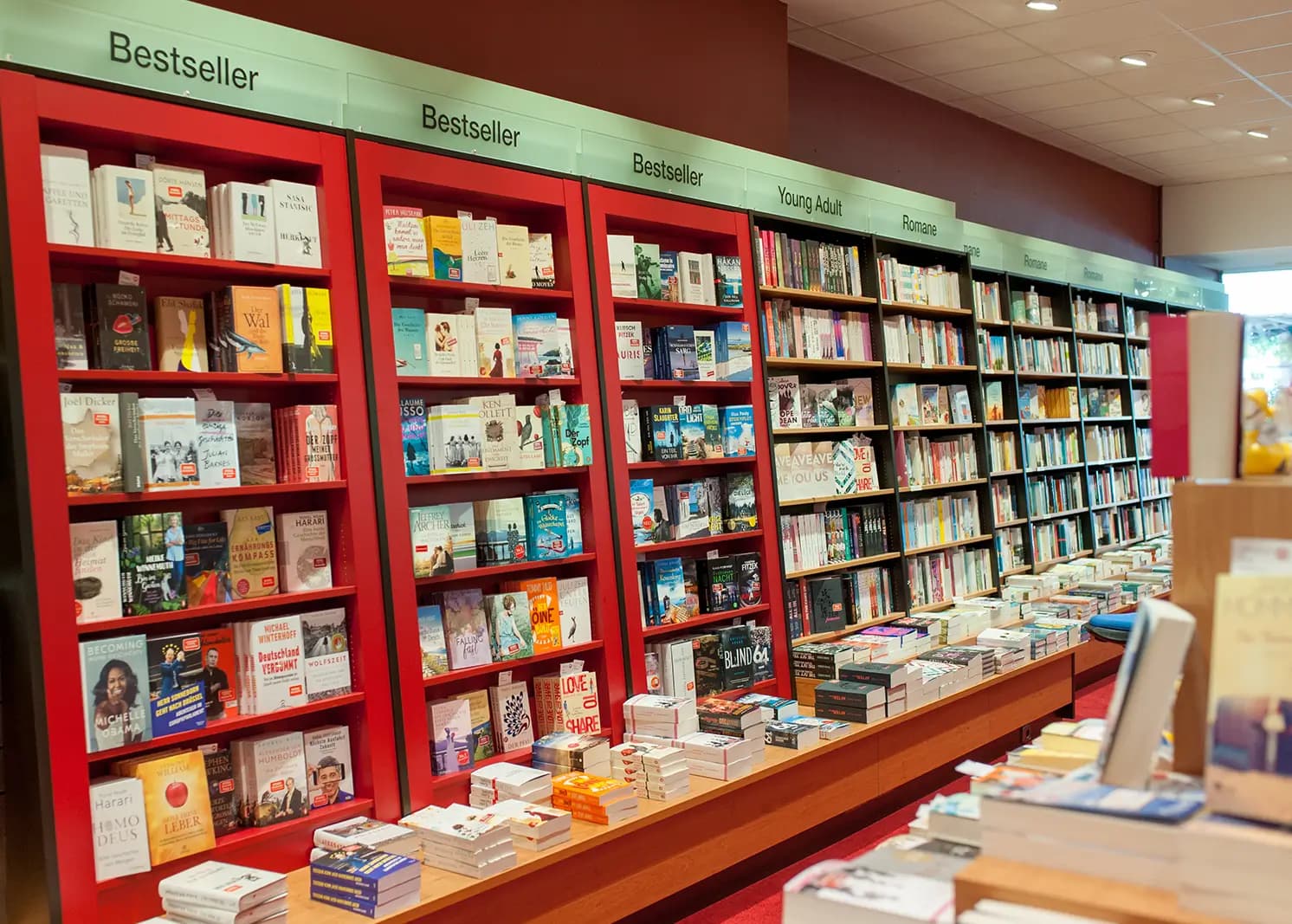 Ein hohes, gut gefülltes Bücherregal in einer Heymann-Filiale, das die Vielfalt des Sortiments zeigt.