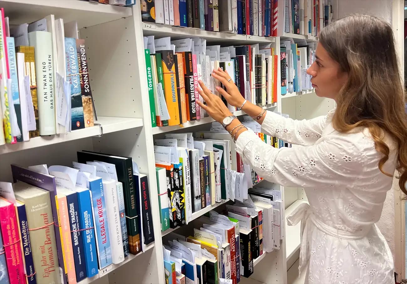 Eine Praktikantin vor einem Bücherregal.