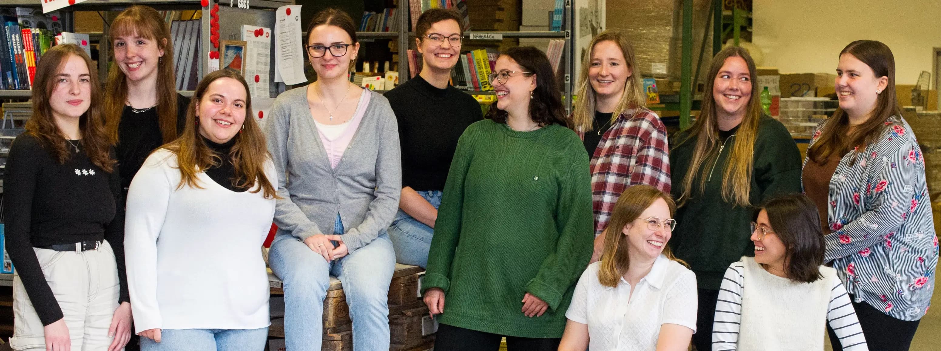 Eine Gruppe junger Heymann-Auszubildender steht lächelnd zusammen.